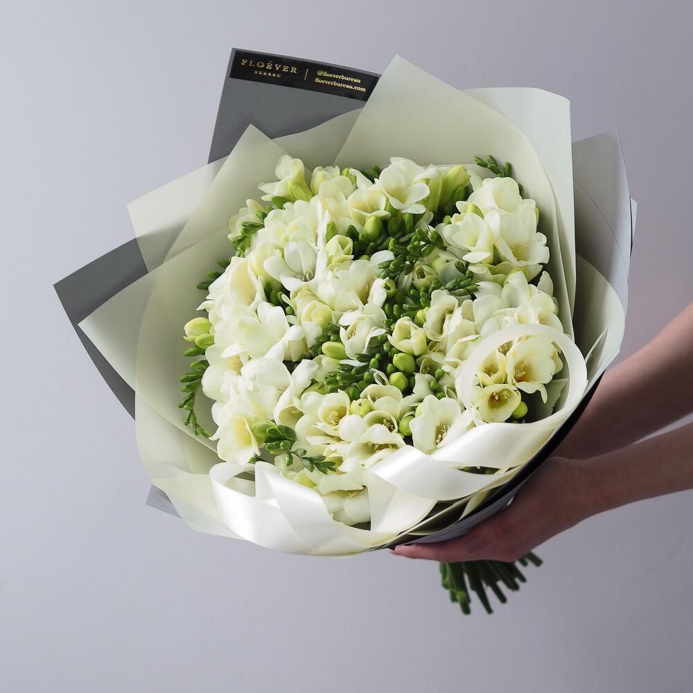 Букет из 11 белых фрезий в пудровой пленке